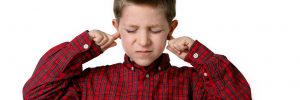 boy with his pointer fingers in his ears
