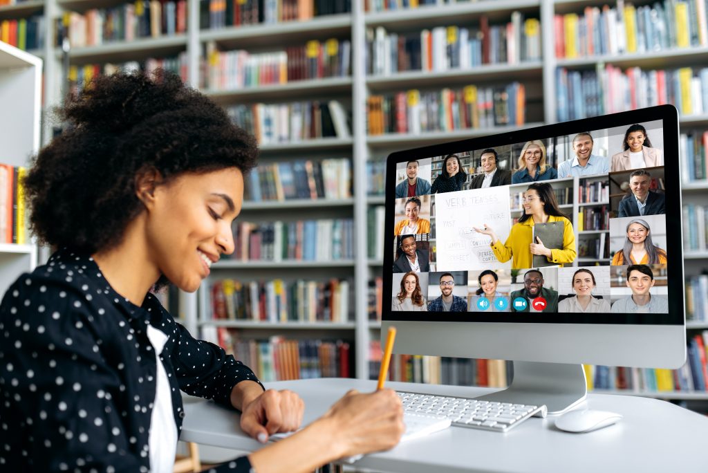 woman watching a webinar and taking notes