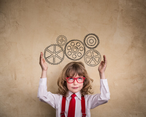 child in red glasses, suspenders, and a necktie with gears drawn above their head