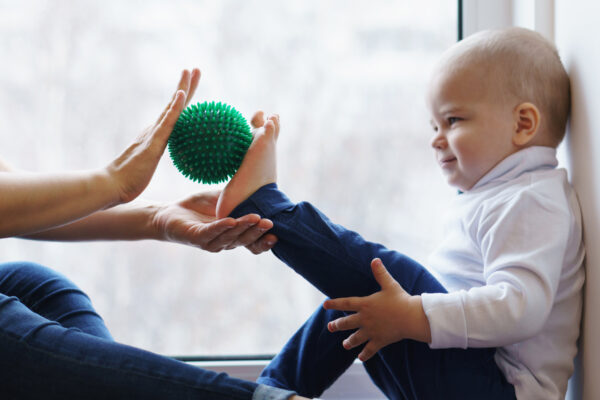 small child working on a foot mobility exercise with a therapist