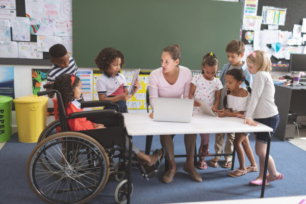 Group of students with teacher using tablet.